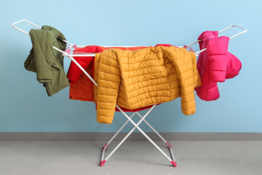 clean,puffer,jackets,hanging,on,dryer,near,blue,wall